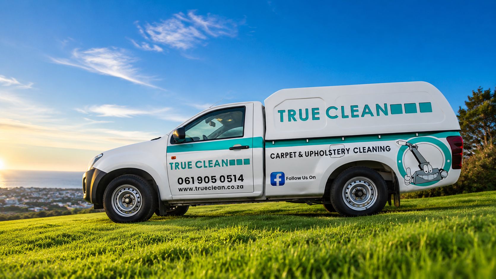 The True Clean bakkie, signwritten for carpet and upholstery cleaning, on the grass above the bay in Gqeberha